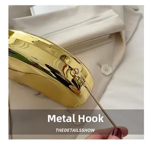 Detail of high-gloss gold acrylic evening bag featuring a fine metal chain and sturdy clasp