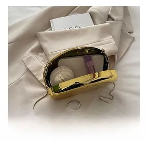 Detail of gold shiny acrylic clutch showing internal space for lipstick and cosmetics