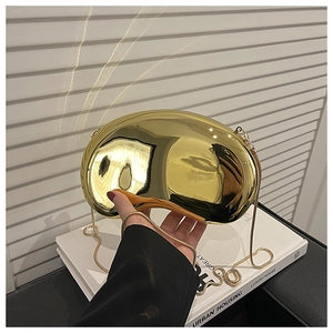 Detailed view of shiny gold kidney-shaped acrylic clutch with detachable chain strap