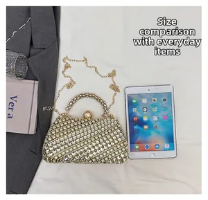 Détail de la pochette dorée à strass montrant la taille réelle par rapport à une tablette