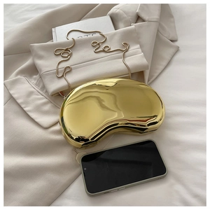 Close-up of golden bean-shaped acrylic clutch with metallic mirror finish and chain