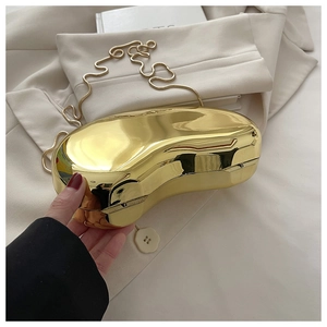 Detail of a golden bean-shaped acrylic evening clutch bag with high gloss mirror finish