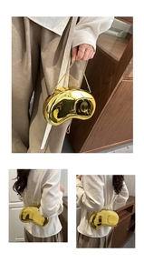 Close-up of golden bean-shaped metal evening bag with mirror finish and slim chain strap