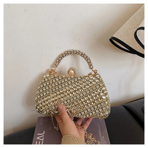 Détail du sac de soirée doré avec strass, fermoir perle et bandoulière en chaîne