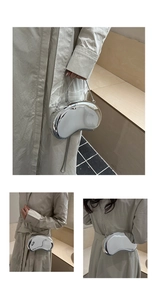Detail view of a silver mirror finish cashew-shaped acrylic clutch with metal chain strap