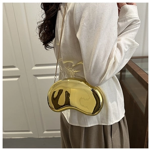Detailed view of the mirror-finished golden kidney bean clutch with a metal chain strap