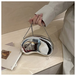 Close-up of a silver bean-shaped acrylic clutch with a high-gloss mirror finish and chain