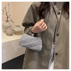 Détail du sac de soirée en strass argenté avec fermoir perle et poignée étincelante