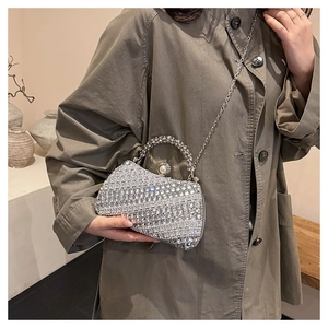 Détail du sac de soirée argenté avec strass brillants et fermoir en perle