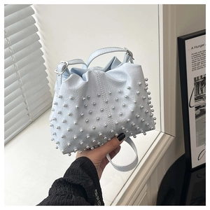 Dettaglio della borsa a tracolla azzurra con perle, texture in PU e fibbie argento