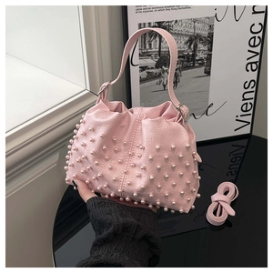 Dettaglio della borsa a secchiello rosa arricciata con perle e trama in pelle litchi