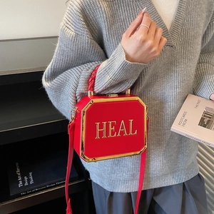 Fashionable red octagon box bag with golden HEAL letters and metallic trim detail