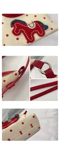 Close-up of red pony embroidery and polka dots on a cream canvas shoulder bag
