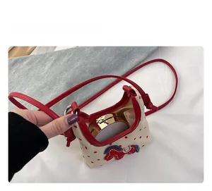 Interior view showing capacity for cushion and lipstick in mini polka dot horse bag