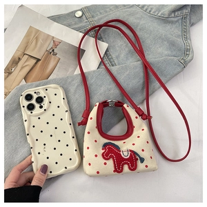 Detail of mini canvas crossbody bag with red pony embroidery and polka dot patterns