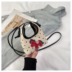Detail of canvas mini bag with polka dots and handmade pony embroidery charm