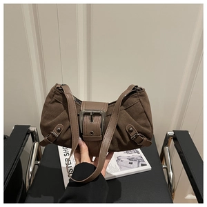 Détails du sac à bandoulière en daim marron foncé avec boucles vintage et design courbé
