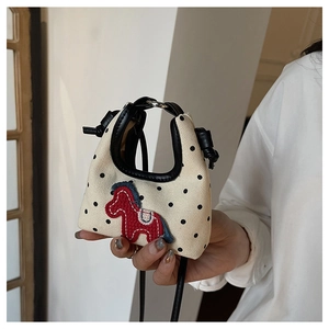 Close-up of red pony embroidery on beige polka dot canvas mini crossbody handbag
