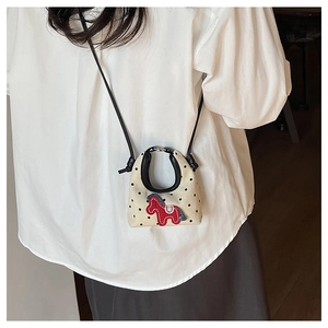Close-up of mini polka dot canvas bag featuring cute pony embroidery on model