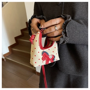 Detail of mini canvas tote bag featuring red polka dots and a cute horse embroidery