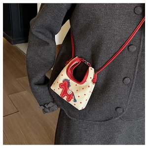 Detail of mini crescent canvas crossbody bag with red polka dots and pony embroidery