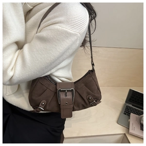 Dettaglio della borsa baguette vintage in pelle scamosciata marrone con fibbia in metallo