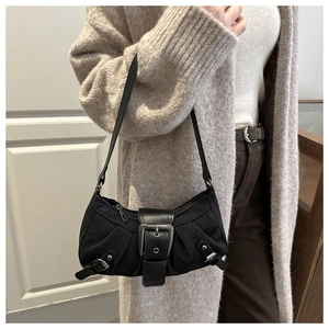 Dettaglio della borsa a spalla nera vintage con fibbie metalliche e borchie stile biker