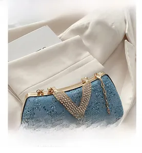 Macro detail of blue lace evening clutch with V-shaped rhinestone metal hardware