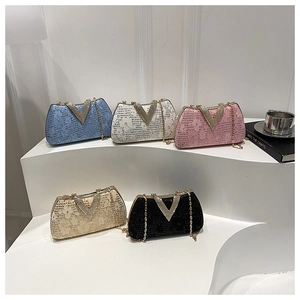 Close-up of floral lace texture and diamond-encrusted V-shaped buckle on chain bag