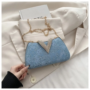 Detail of light blue floral lace clutch featuring a large rhinestone V-shaped buckle