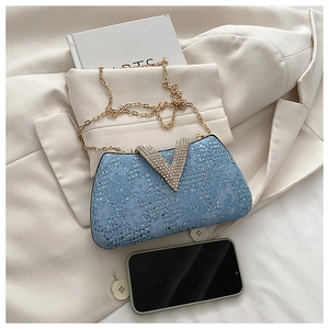 Detailed macro of blue lace evening bag with sparkling V-shaped rhinestone metal buckle