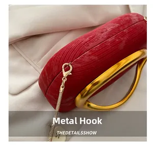 Detail of red striped evening bag with elegant gold metal hook and chain link