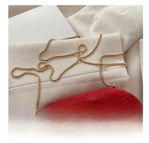 Detail of red textured clutch featuring gold semicircular handles and sleek snake chain