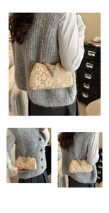 Detail of evening clutch with lace floral texture and crystal V-shape buckle