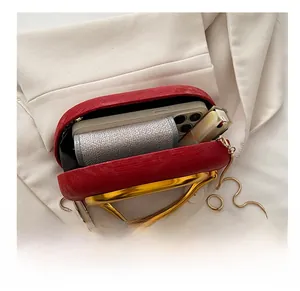 Interior view showing capacity of red evening clutch with phone and lipstick details