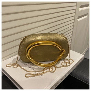 Detail of gold evening clutch with brushed metallic texture and sculptural handle