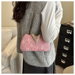 Detailed view of pink lace rhinestones party clutch with large V-shaped gold buckle