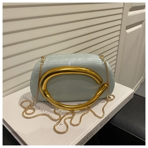Detail of mint green evening clutch with ribbed texture and gold C-shaped handle