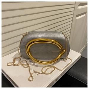 Detail of silver textured evening clutch with gold C-handle and metallic snake chain strap