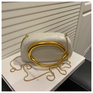 Detail of white evening clutch with silk texture, gold C-handle and metal chain strap