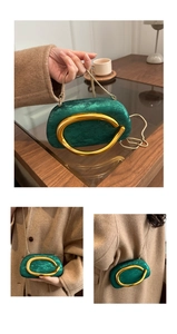 Detail of emerald velvet evening clutch bag featuring a gold ring clasp and chain strap