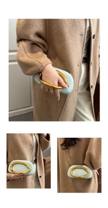 Detail of light blue box clutch with textured surface and designer gold metal ring handle