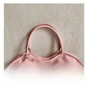 Gros plan du sac à main rose à motif d'étoiles avec poignée ronde et pendentif étoile