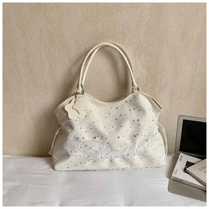 Détail du sac à bandoulière crème avec broderie Badblood et imprimés d'étoiles argentées