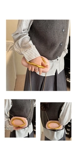 Detail of pink oval clutch with shell texture, gold U-handle and metallic chain strap