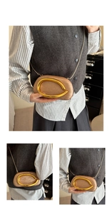 Detail of champagne gold silk evening clutch with metallic handle and chain strap
