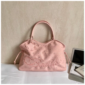 Détail du sac seau en daim rose avec étoiles argentées et logo Badblue brodé sur le côté