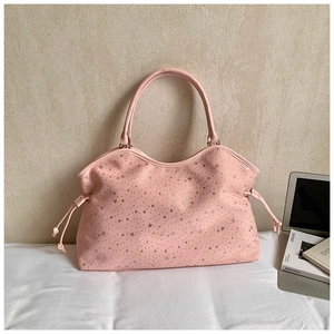 Détail d'un sac cabas rose en simili cuir avec motifs étoiles argentées et cordons latéraux