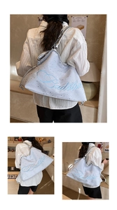 Détail du sac seau bleu clair avec étoiles argentées et broderie de marque sur le côté