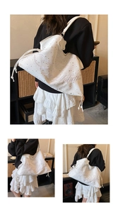Détail du sac blanc avec imprimé étoiles, broderie Melle et breloque en forme d'étoile